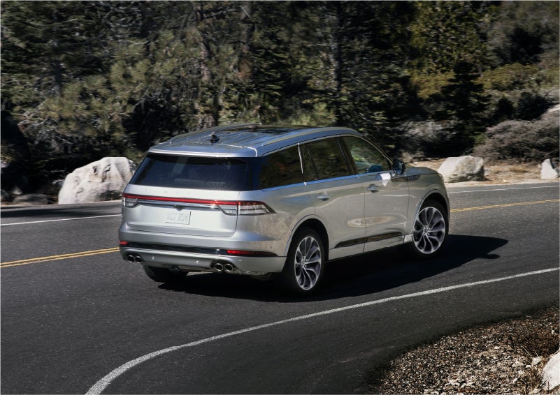 A 2023 Lincoln Aviator® Grand Touring model is shown being driven on a tight turn of a mountain road | Ted Russell Lincoln in Knoxville TN