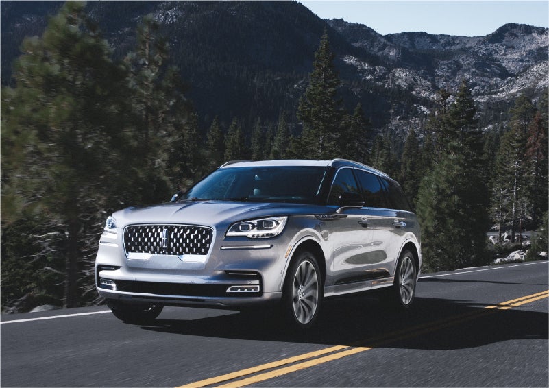 A 2023 Lincoln Aviator® Grand Touring SUV being driven on a winding road to demonstrate the capabilities of all-wheel drive | Ted Russell Lincoln in Knoxville TN